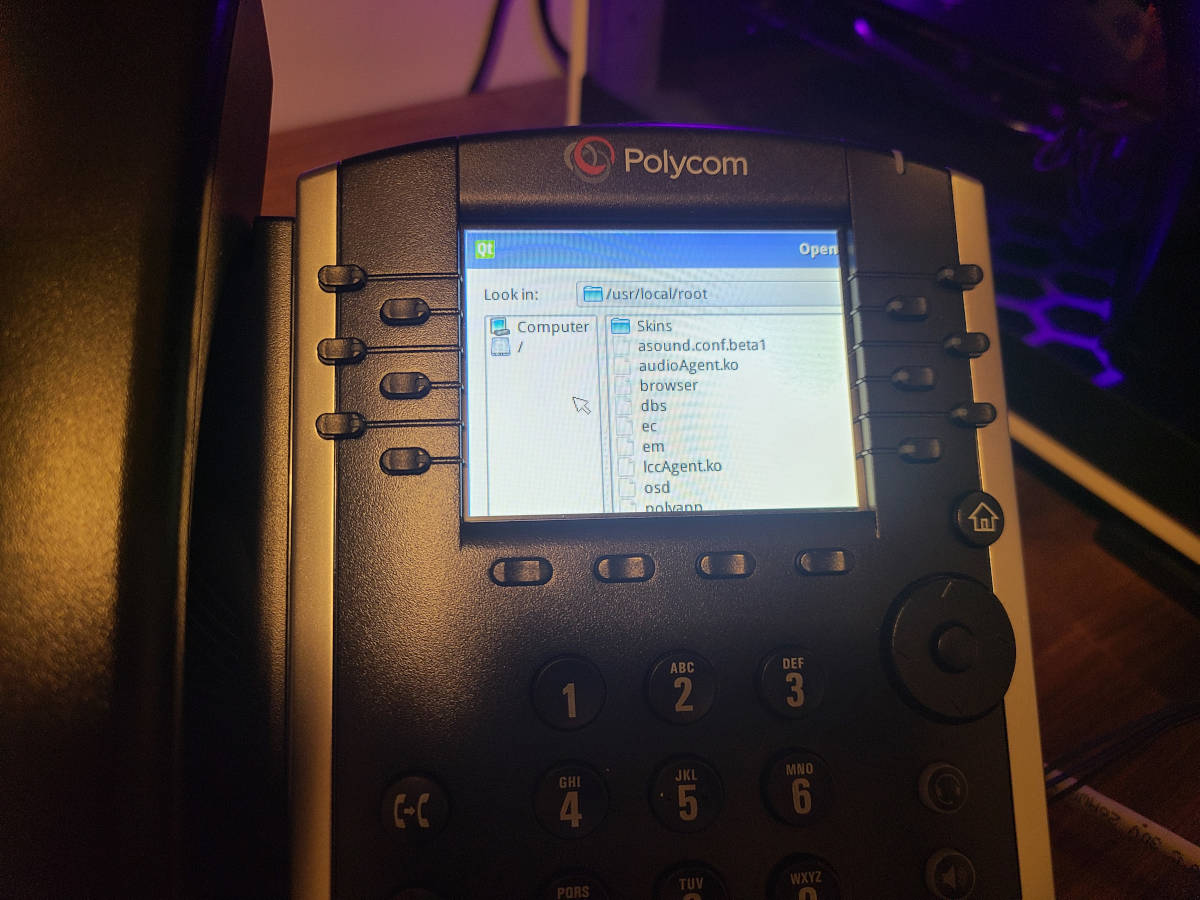 An office desk phone, but the screen is showing a file browser instead of typical phone things.