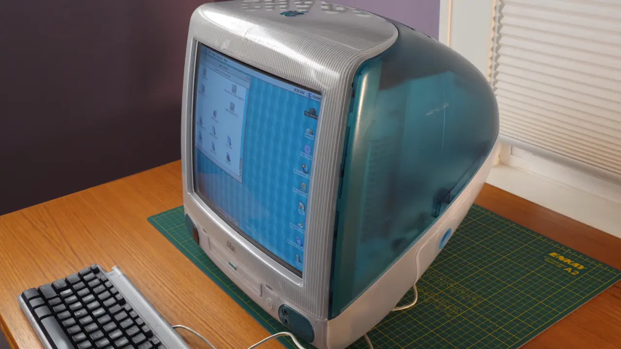 An iMac G3 (a translucent 90s all-in-one computer) cleaned up on a table. 